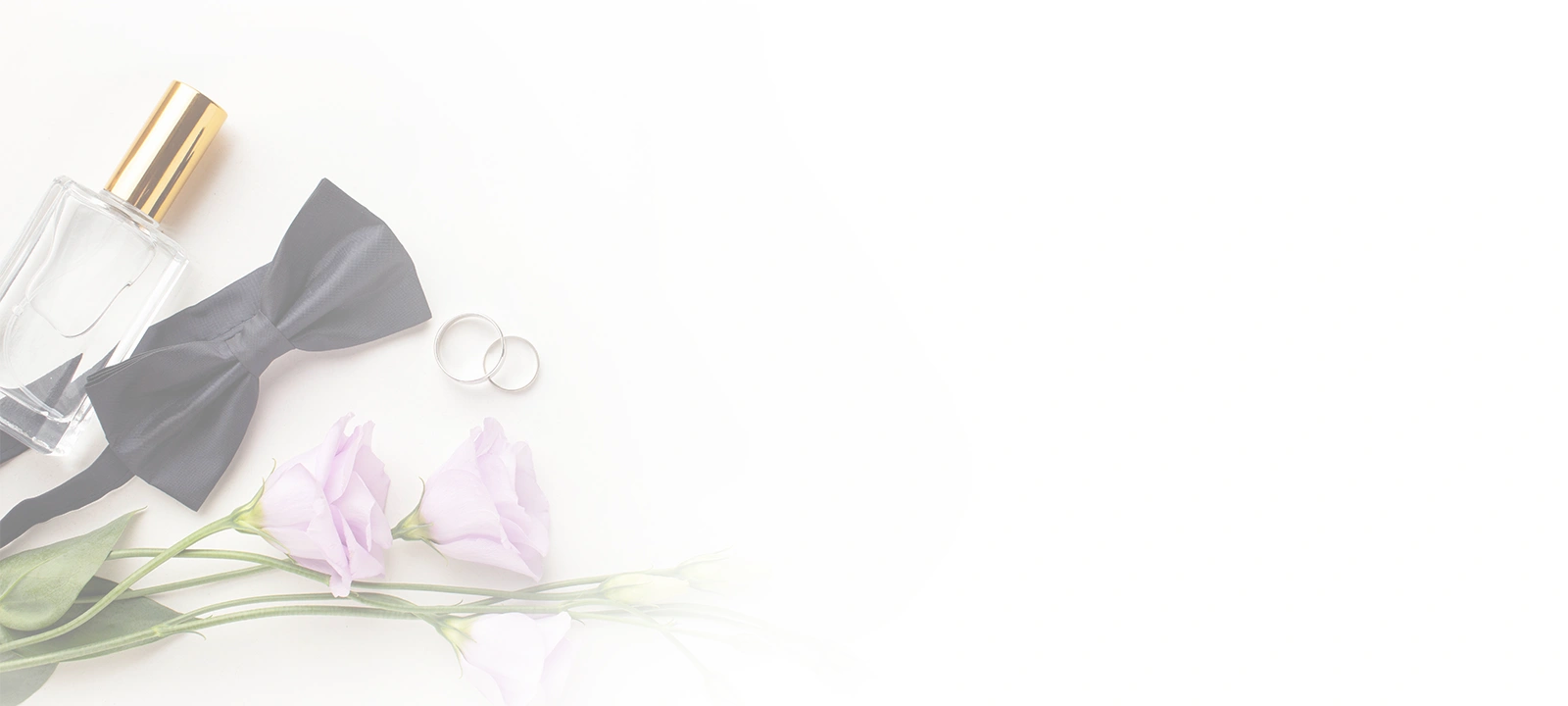 Layout piatto di oggetti per il matrimonio,
                                    tra cui un papillon nero, due fedi d'argento, una
                                    bottiglia di profumo e fiori viola chiaro su
                                    sfondo bianco.